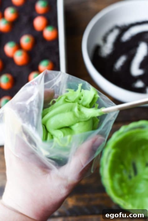 Green frosting being stuffed in a piping bag.