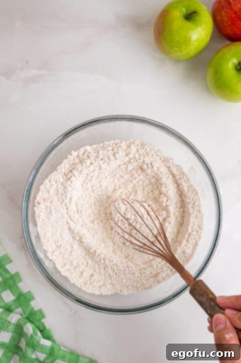 A bowl with dry cake ingredients being whisked.