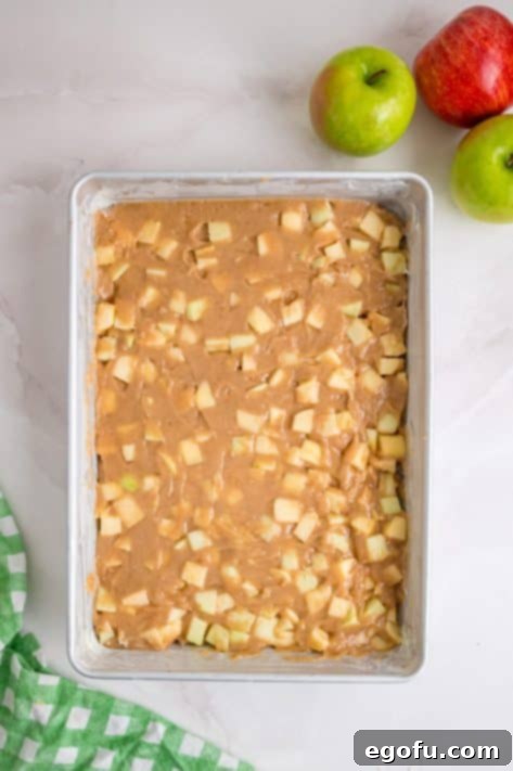 Apple dapple cake batter spread into baking dish.