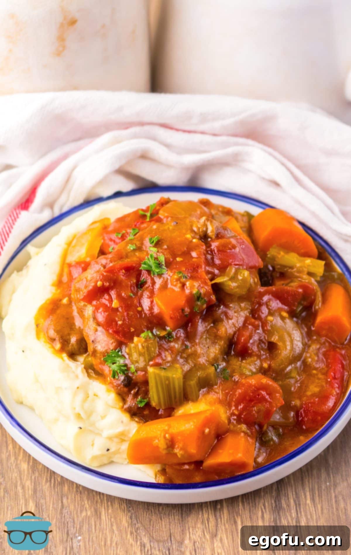 A plate of mashed potatoes and Crock Pot Swiss Steak.