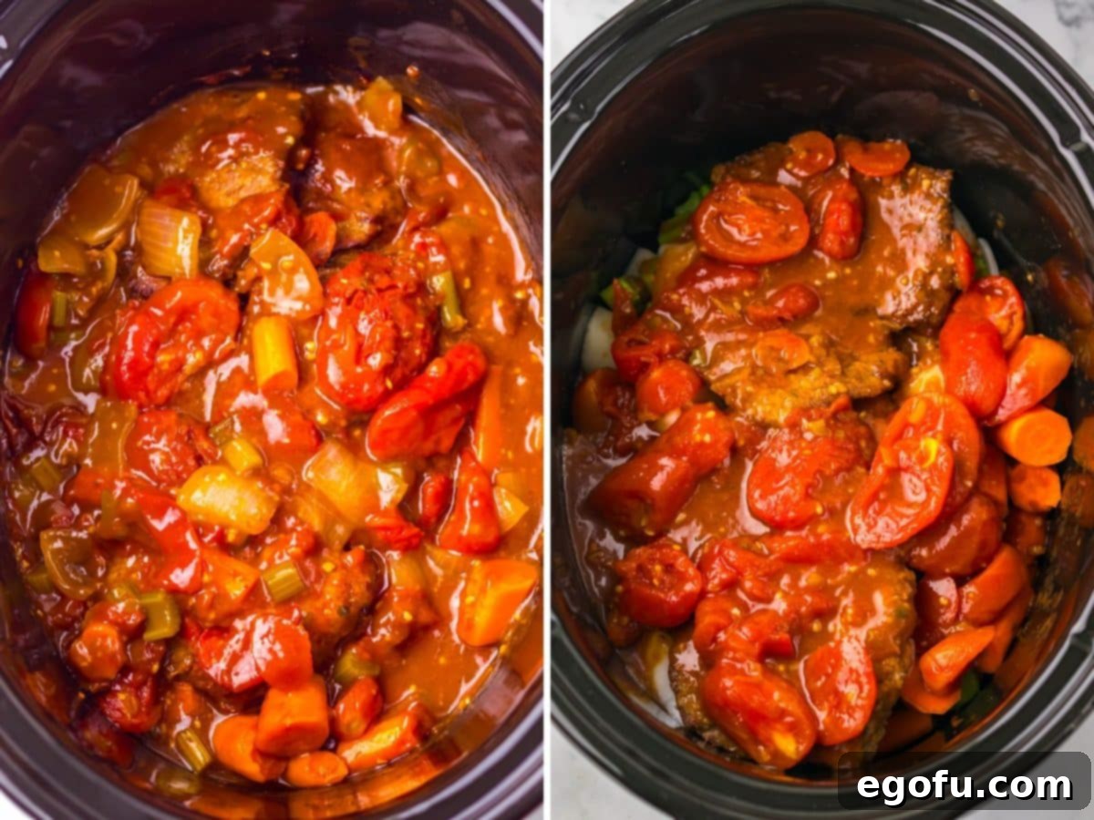 Veggies and juices overtop a cubed steak and more vegetables in a Slow Cooker.