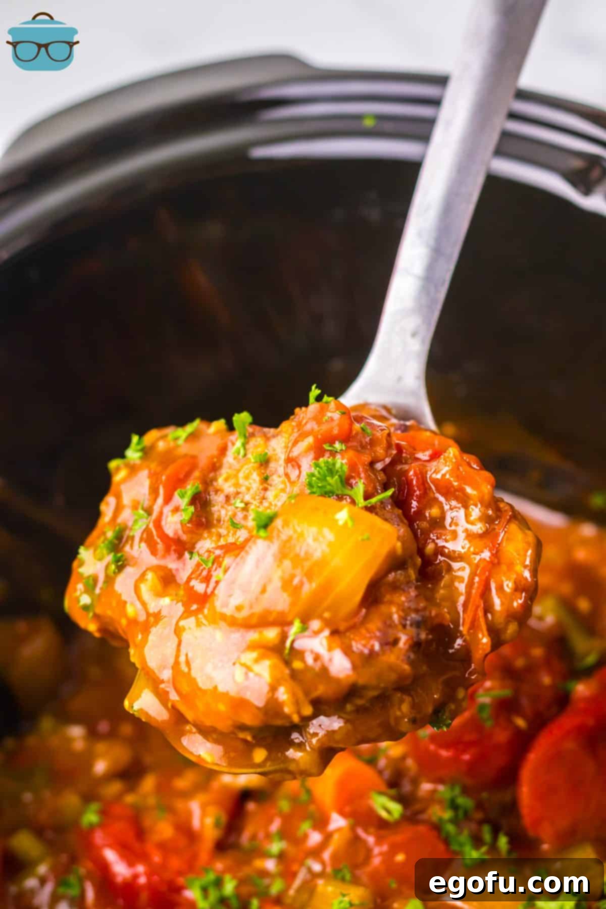 A big scoop of Swiss Steak above the Crockpot.