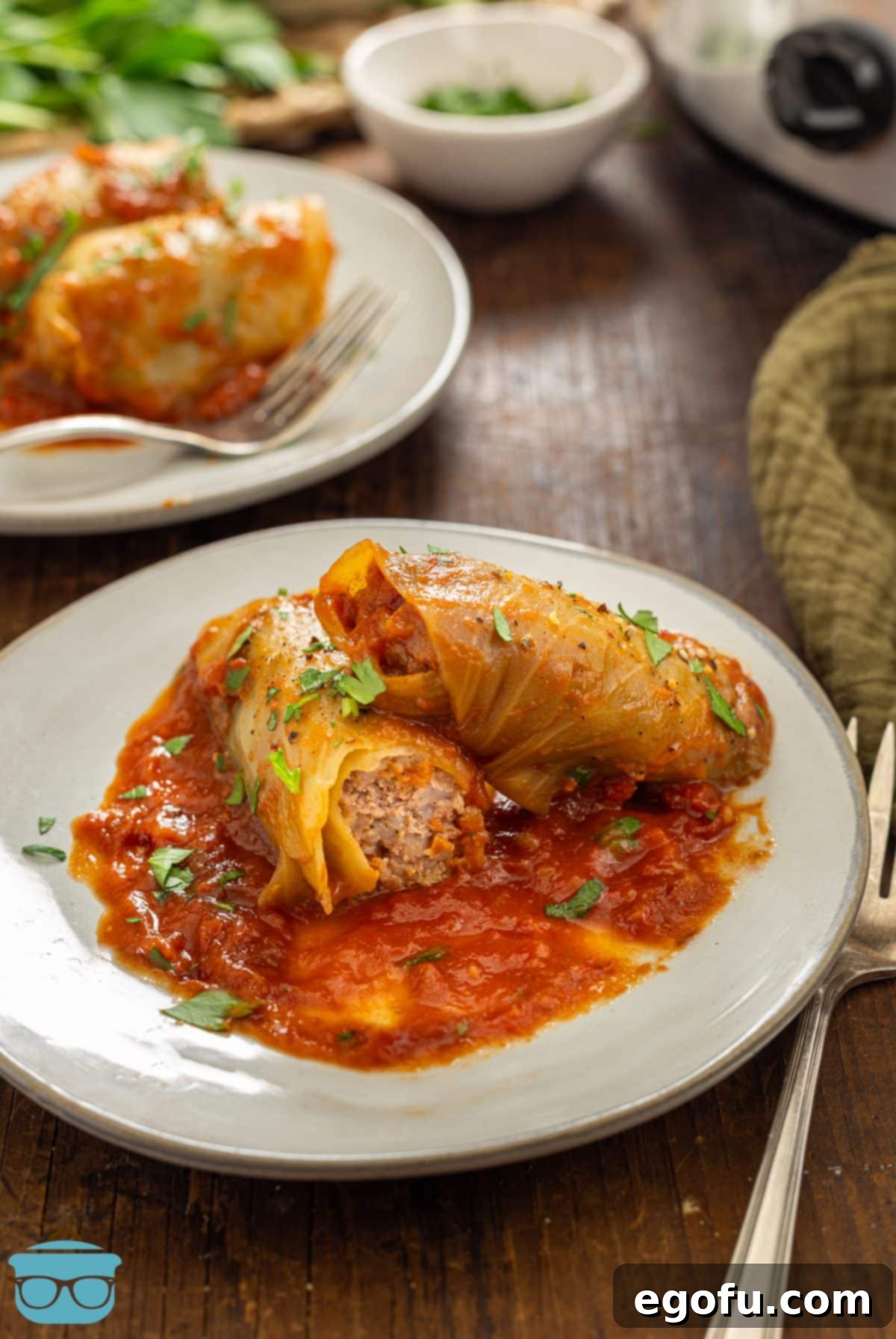 Effortless Crock Pot Cabbage Rolls 2 A few plates of Tender Crock Pot Cabbage Rolls with a generous pour of tomato sauce.