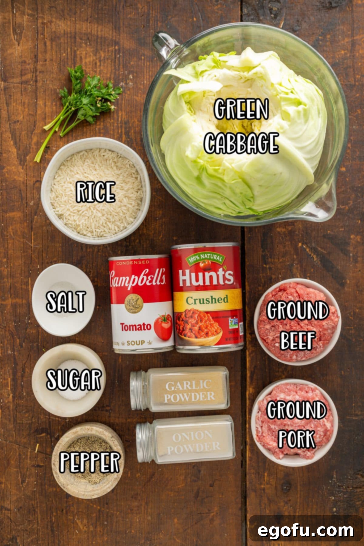 Effortless Crock Pot Cabbage Rolls 4 Arrangement of fresh green cabbage, cooked rice, various spices, crushed tomatoes, ground beef, ground pork, and tomato soup.