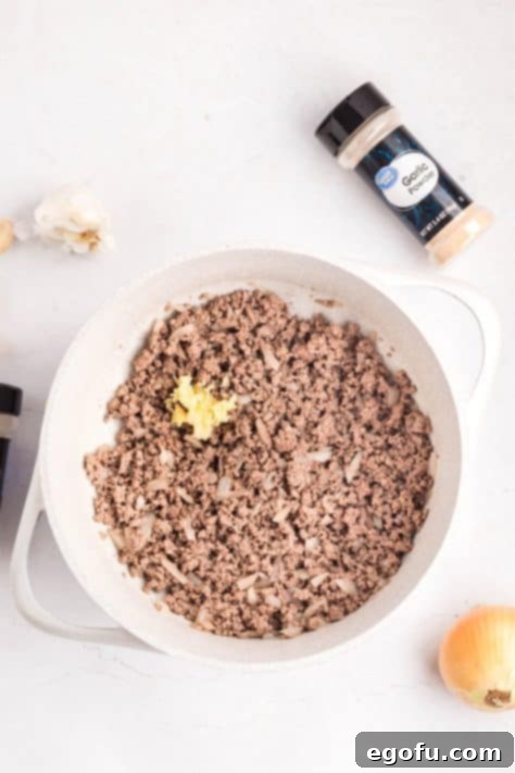 Ground beef, onions, and garlic in a skillet.