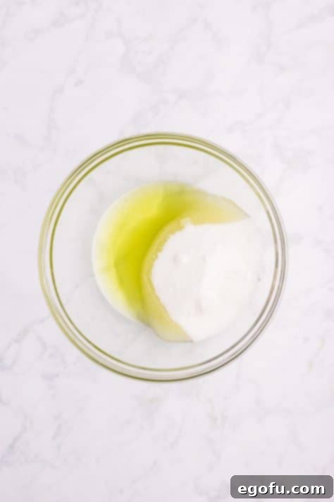 A bowl with oil, sugar, flour, baking powder, baking soda, and salt.