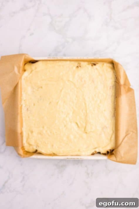 The final layer of cake batter carefully spread over the apples and the first layer of streusel in the baking pan.