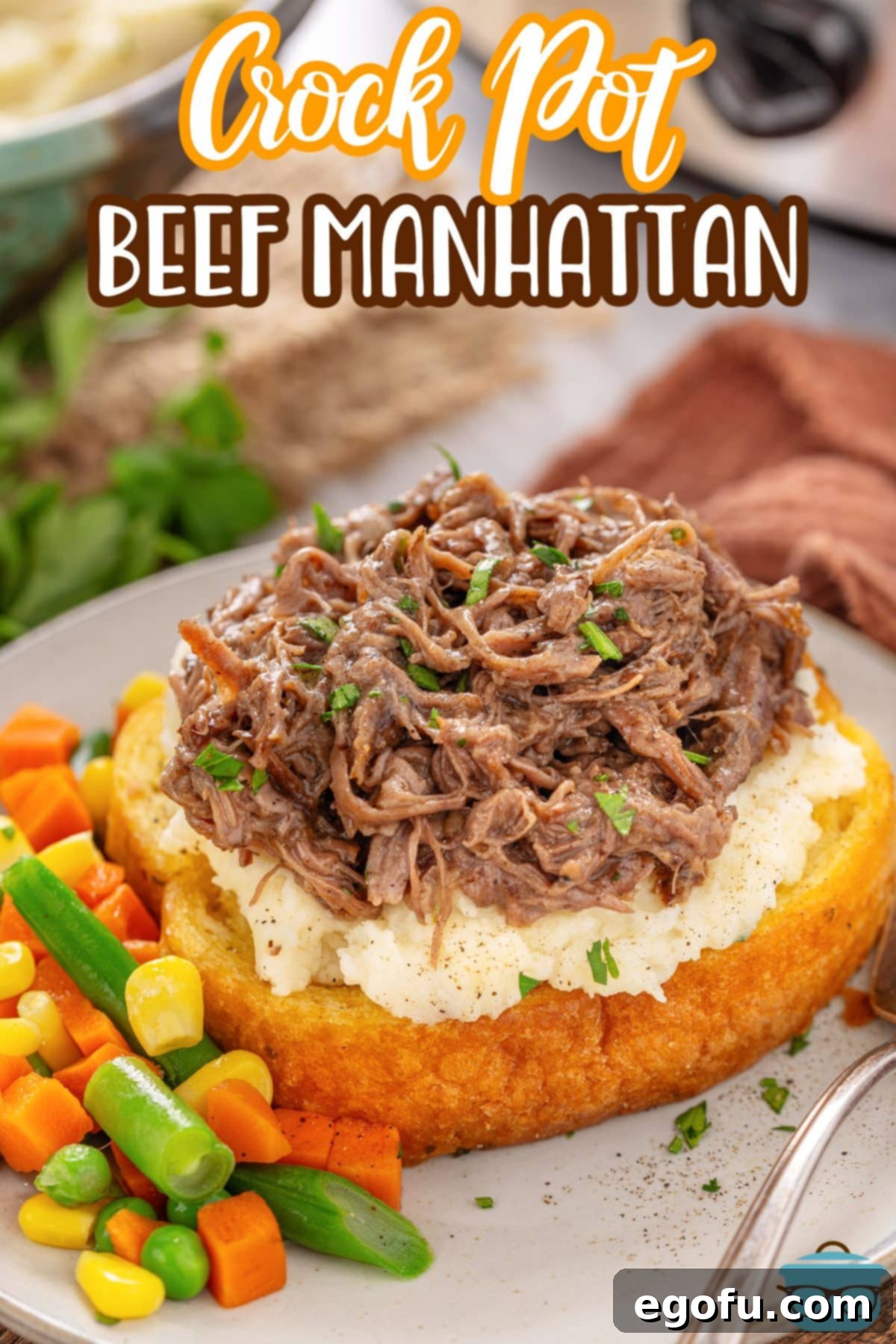 An overflowing Beef Manhattan Texas Toast with a side of vegetables.