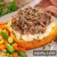 An overflowing Crock Pot Beef Manhattan with a side of veggies.