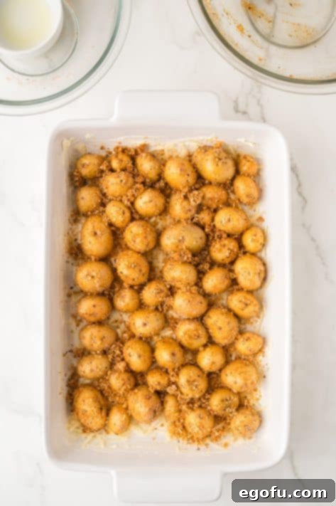 Potatoes and spices in a baking sheet.