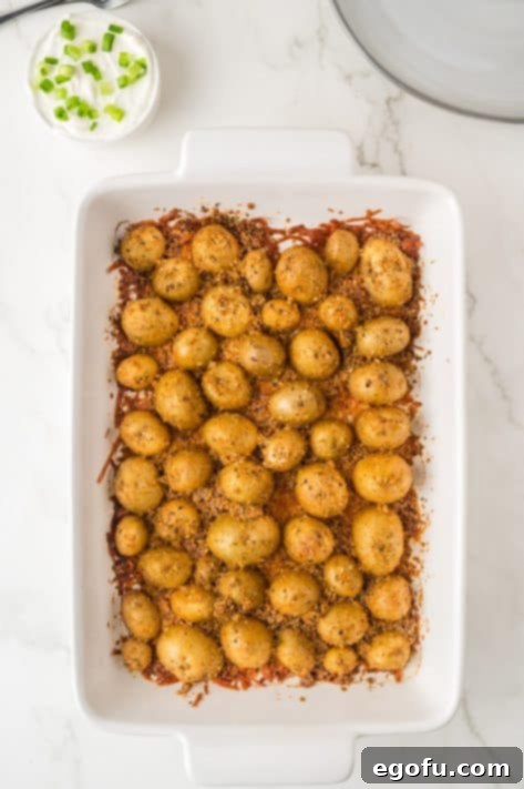 Cheese and spice coated potatoes in a baking dish.