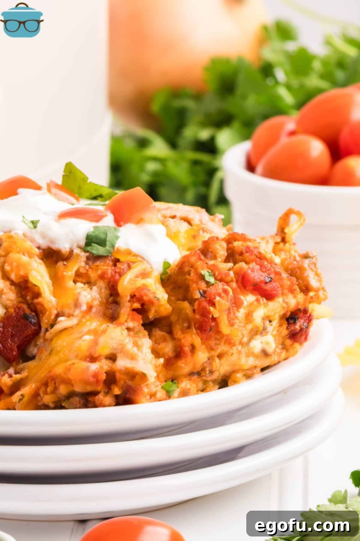Slow Cooker Fiesta Lasagna 2 Close up looking at a serving of Crock Pot Mexican Lasagna on a stack of white serving plates.