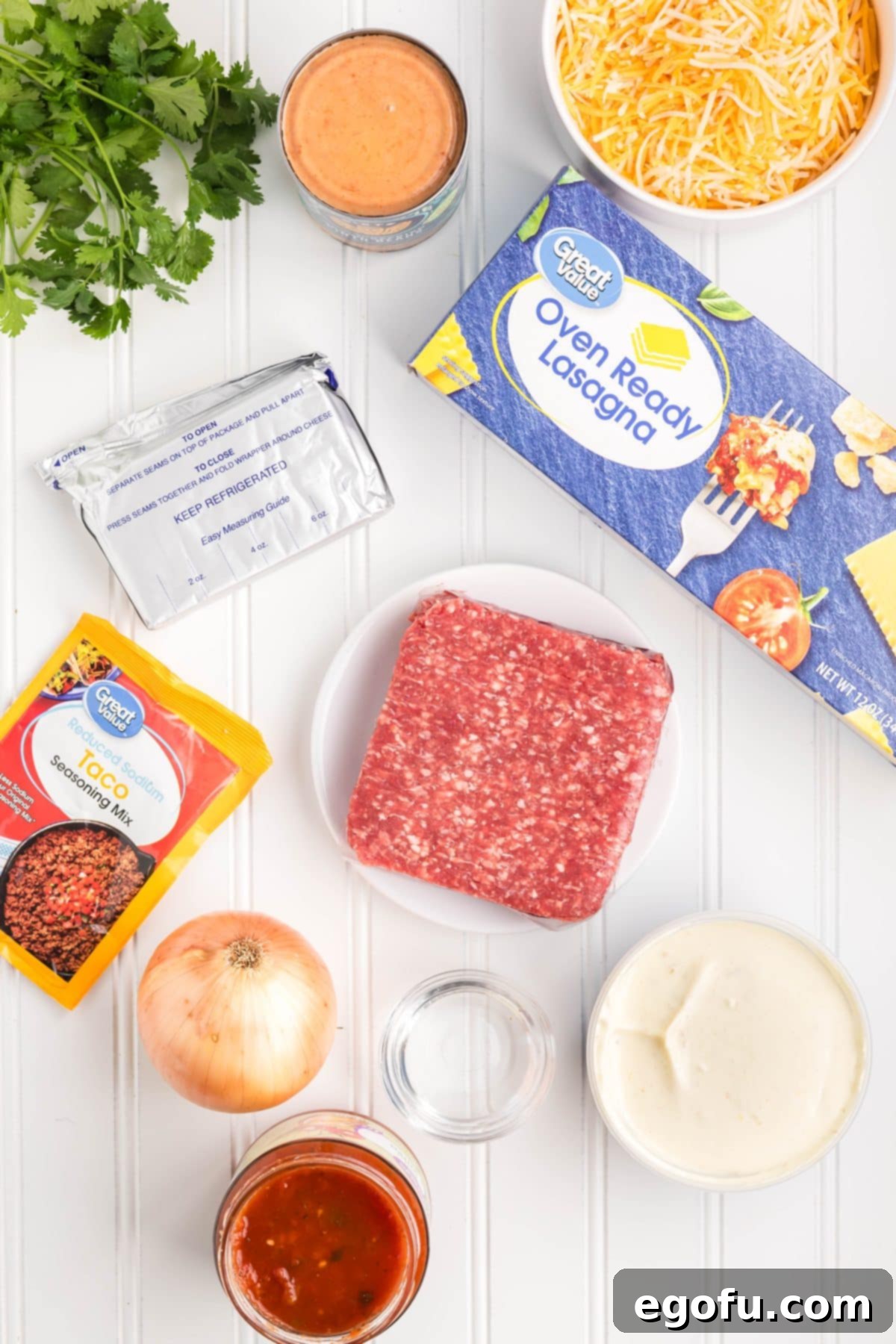 Slow Cooker Fiesta Lasagna 4 Oven ready lasagna noodles, ground beef, onion, taco seasoning, cream cheese, refried beans, queso, water, salsa, cilantro, and shredded Mexican cheese blend.