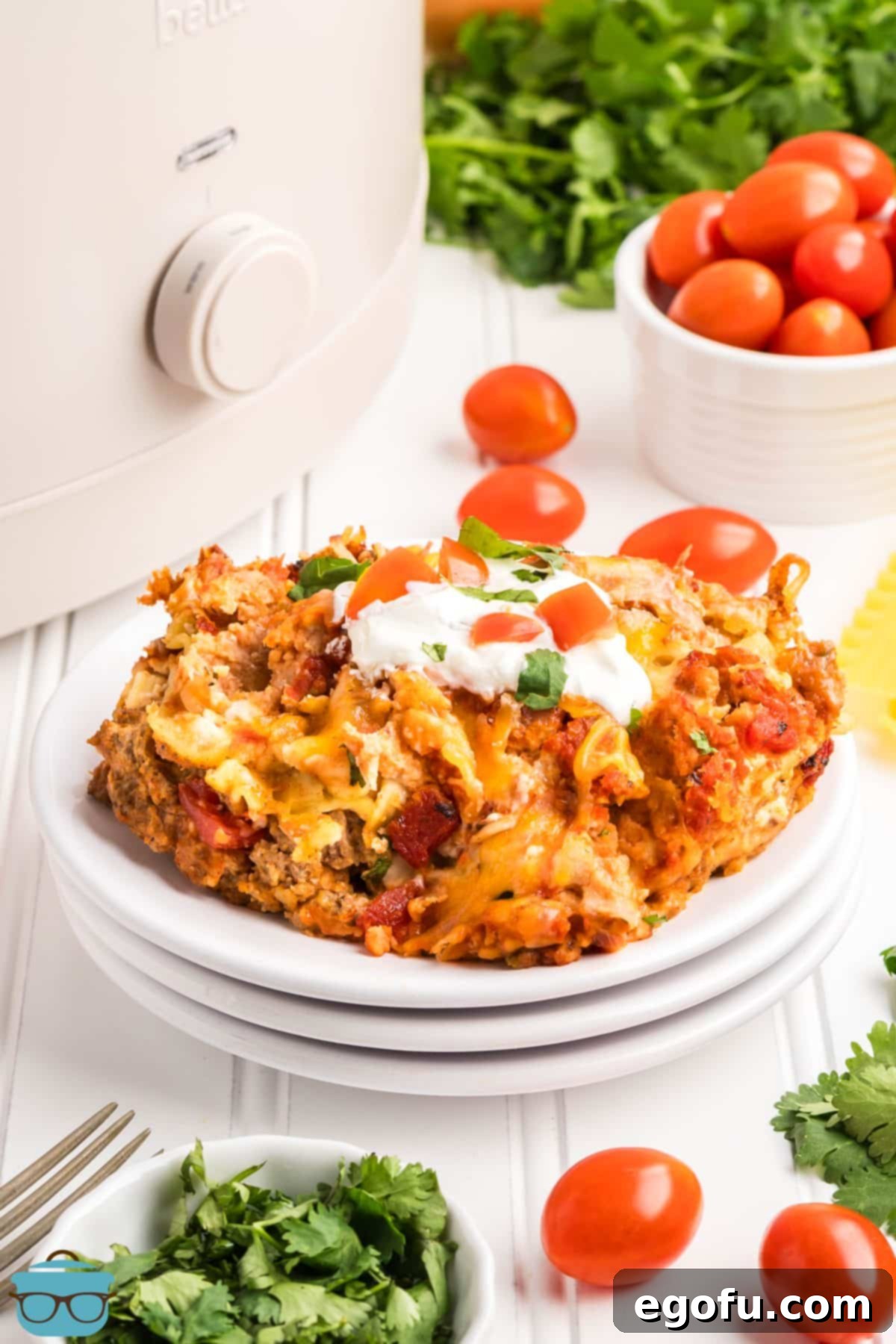 Slow Cooker Fiesta Lasagna 8 A pile of plates with a serving of Crock Pot Mexican Lasagna.