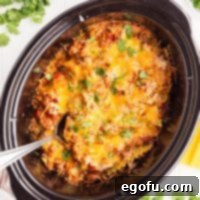 Slow Cooker Fiesta Lasagna 9 Looking down on a serving utensil in a Crockpot full of Mexican Lasagna.