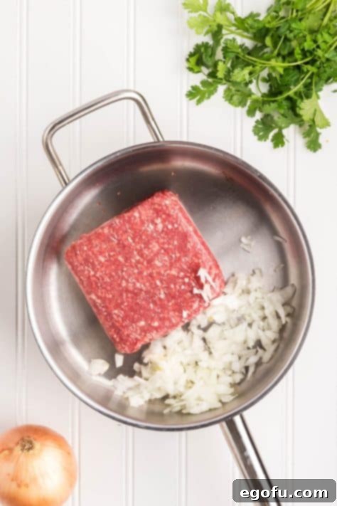 Slow Cooker Fiesta Lasagna 10 Ground beef and onions being cooked in a skillet.