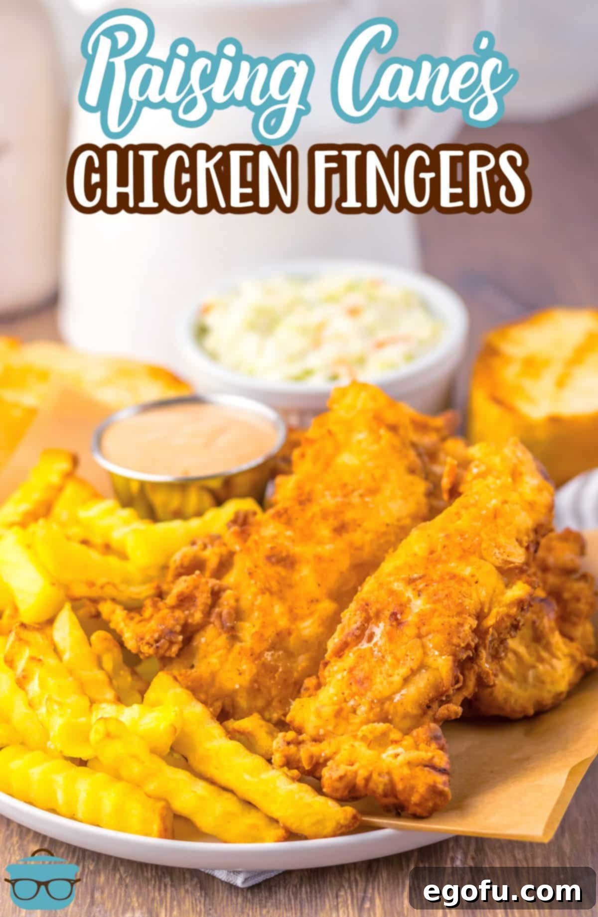 An abundant plate filled with homemade Raising Cane's Chicken Fingers, perfectly golden and crispy, alongside a generous serving of crinkle fries.
