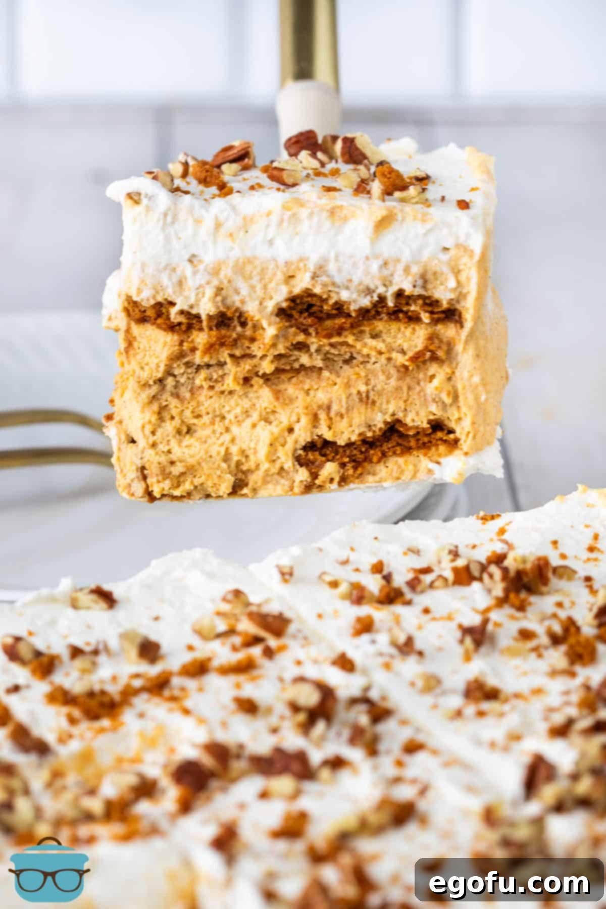 A perfectly sliced piece of No Bake Layered Pumpkin Dessert being lifted from the dish, revealing its distinct layers.