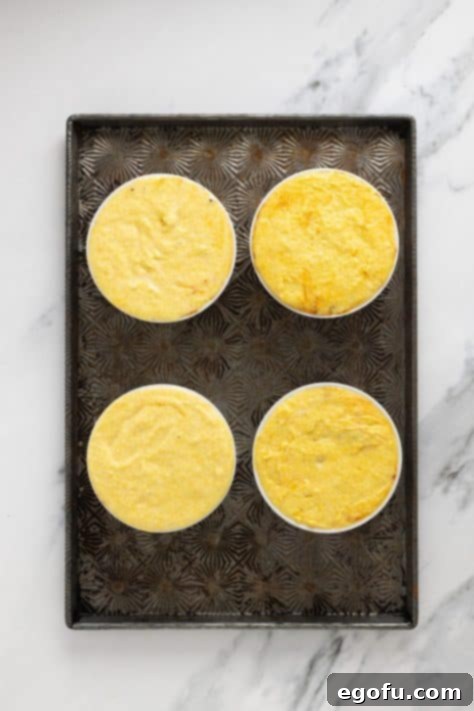 Golden Cornbread Chili Bake 11 Cornbread batter on top of chili in ramekins.