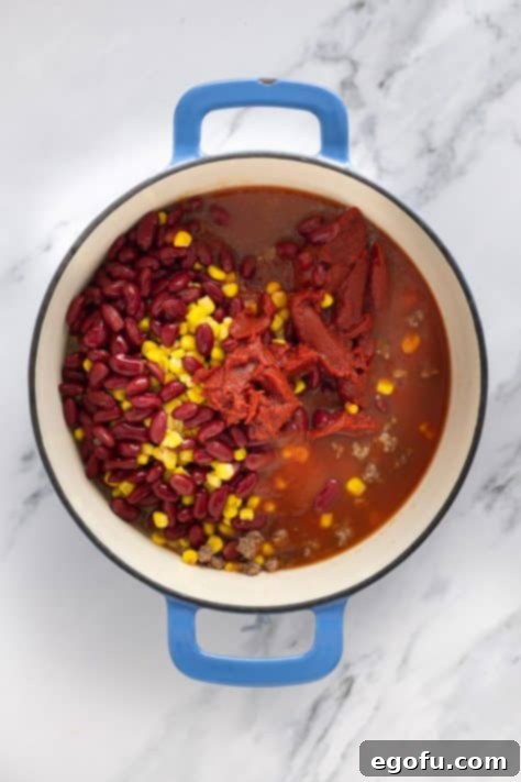 Golden Cornbread Chili Bake 9 A dutch oven with ground beef, beans, corn, tomato sauce, tomato paste and water.