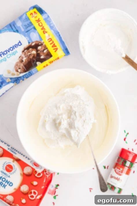 Creamy Cloud Bites 12 Whipped topping being added to melted white chocolate chips, initiating the candy mixture.