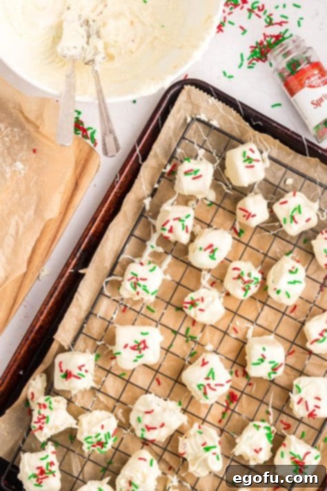 Creamy Cloud Bites 18 Sprinkles being generously added to Cool Whip Candy pieces resting on a wire rack, enhancing their festive look.