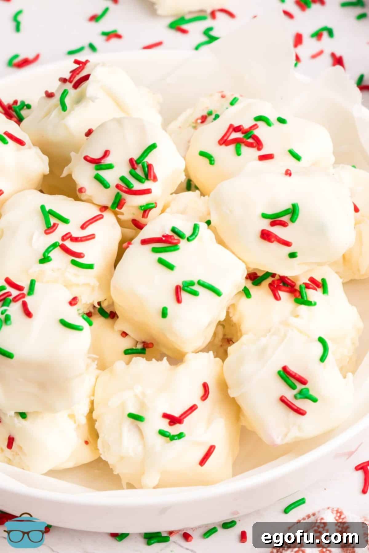 Creamy Cloud Bites 9 A small, inviting pile of finished Cool Whip Candy pieces, glistening with red and green sprinkles, artfully arranged and ready to be served.