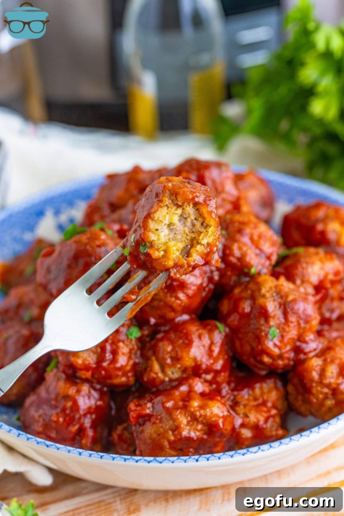 A fork holding a half-bitten Gobbler Meatball, showcasing the stuffing and turkey interior.