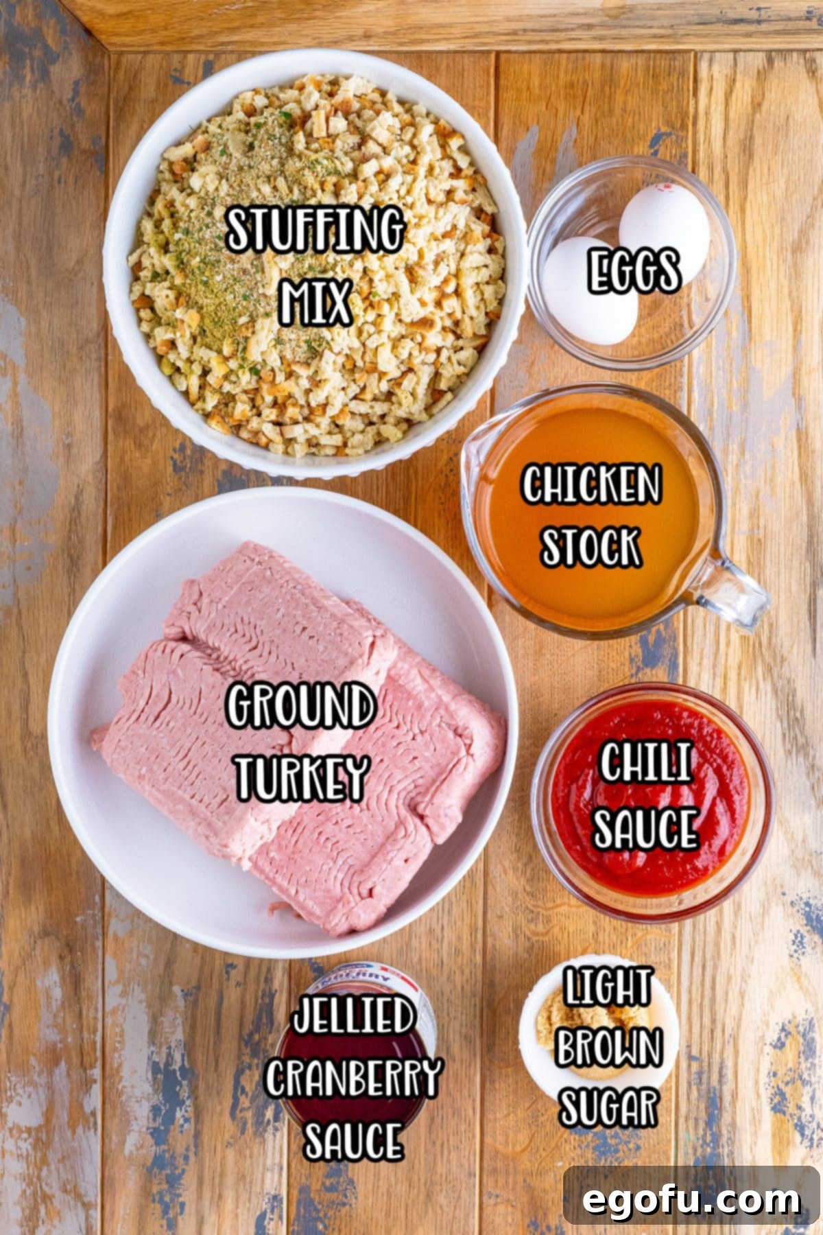 A vibrant display of all the ingredients needed for Slow Cooker Gobbler Meatballs: stuffing mix, ground turkey, chili sauce, eggs, chicken stock, cranberry sauce, and light brown sugar.