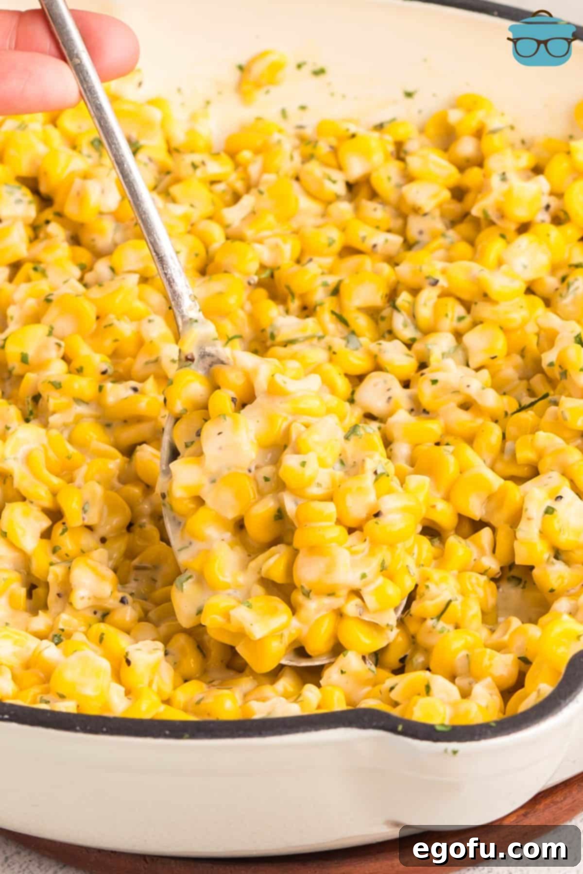 A spoon getting a scoop of Honey Butter Skillet Corn to serve. 