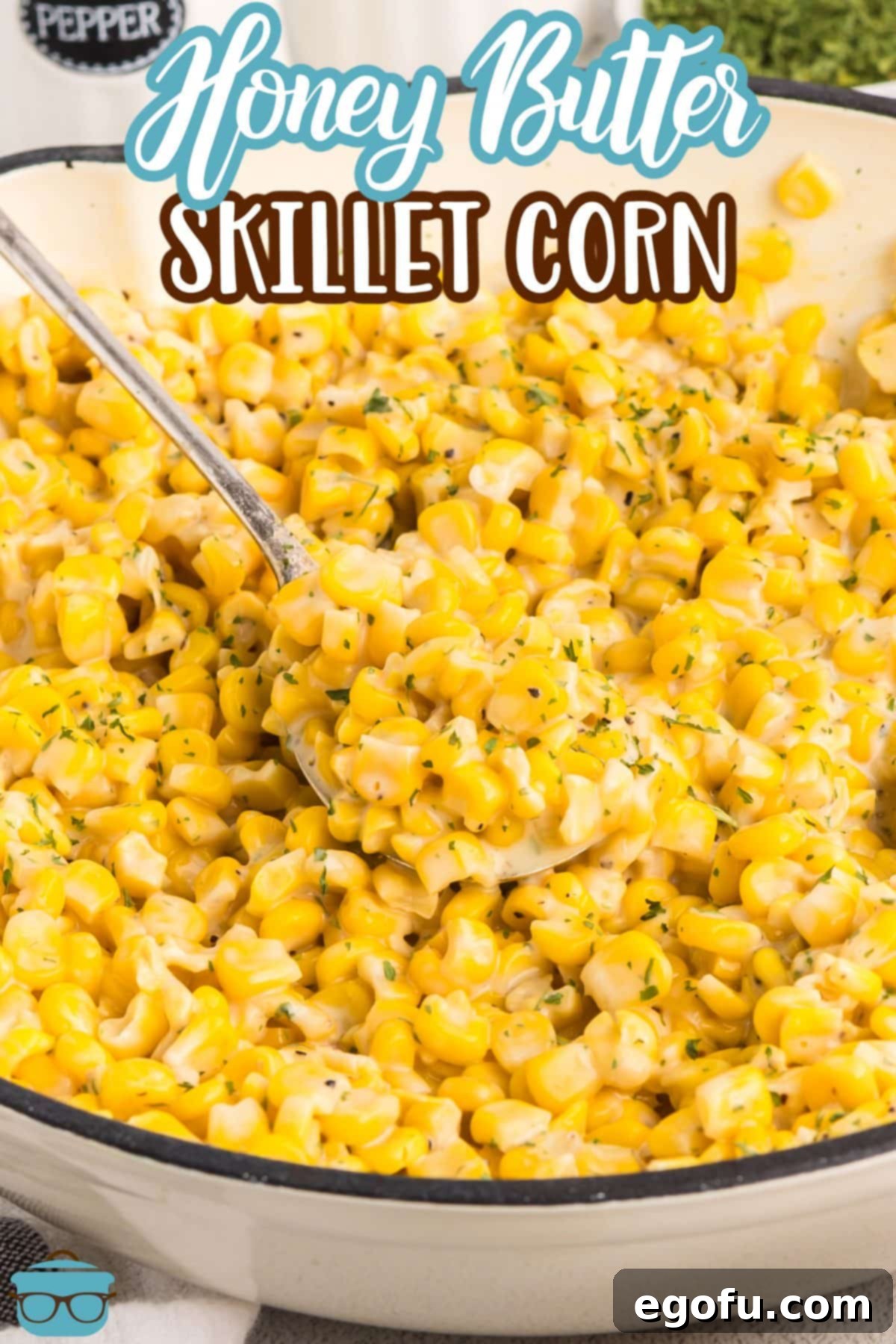 A spoon getting a scoop of Honey Butter Skillet Corn. 