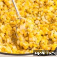 Close up looking at a spoon getting a scoop of Honey Butter Skillet Corn from the dish.