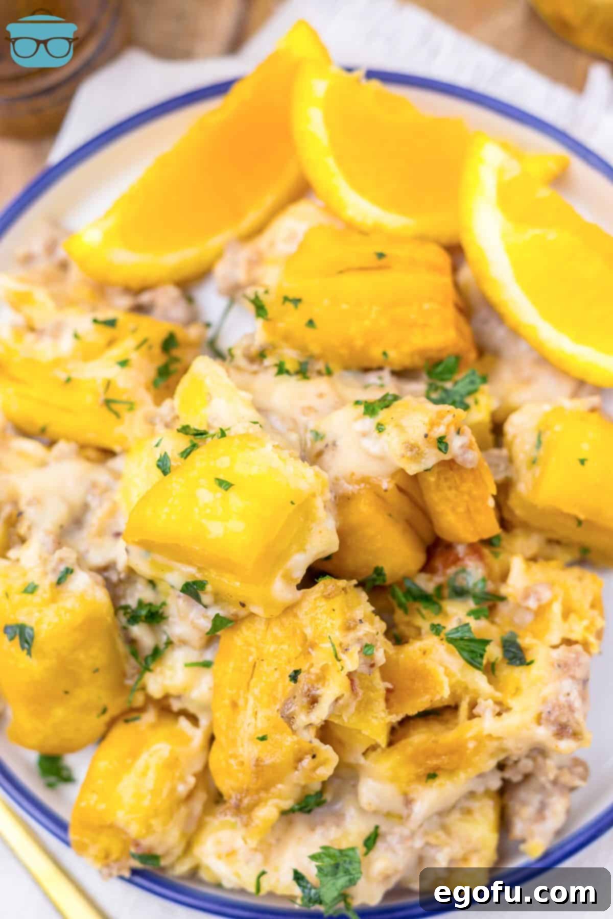 Looking down on a plate of Slow Cooker Sausage Gravy Biscuit Casserole, showcasing its rich texture and golden biscuits.