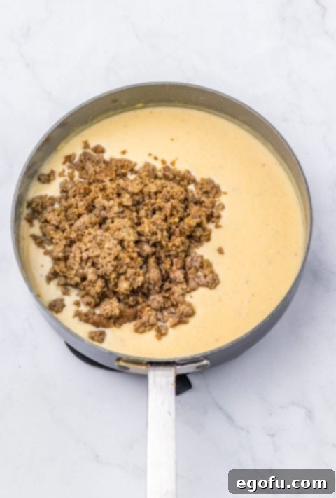 cooked sausage added to gravy in skillet.