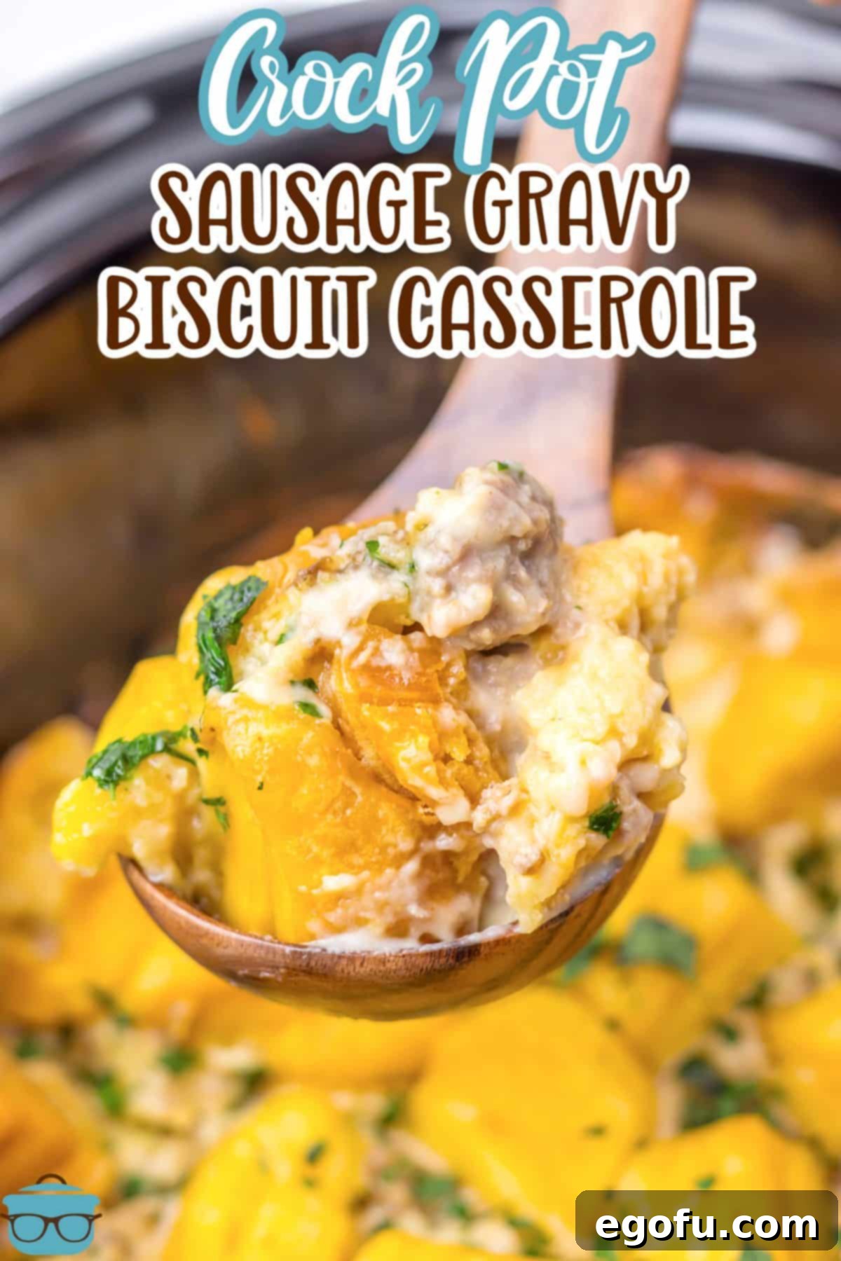A spoon holding a scoop of Crock Pot Sausage Gravy Biscuit Casserole above the Slow Cooker, highlighting its delicious texture.