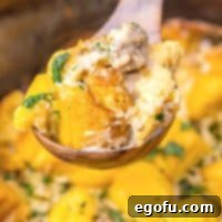 Closely looking at a wooden spoon of Sausage Gravy Biscuit Casserole made in the Slow Cooker, ready to be sampled.