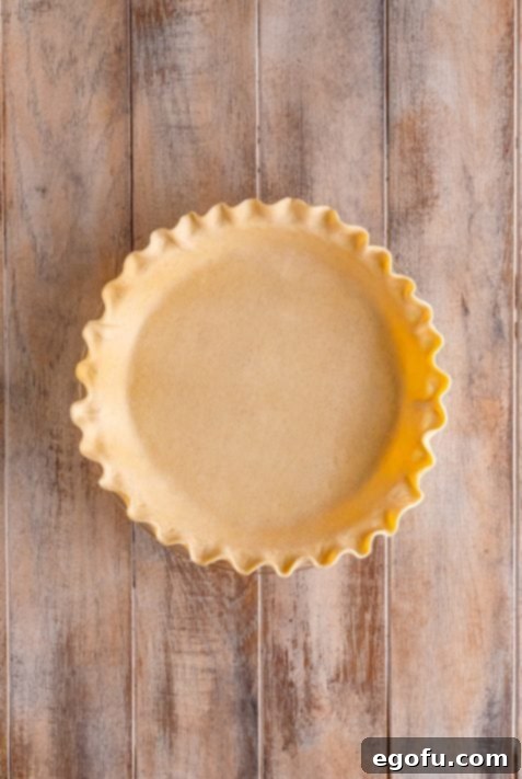 A crimped pie crust perfectly fitted into a pie dish, ready for baking.