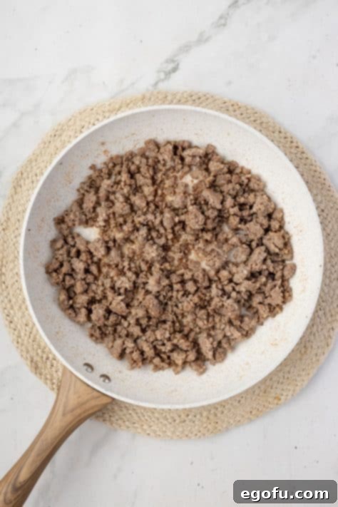 Sausage being cooked in a skillet.