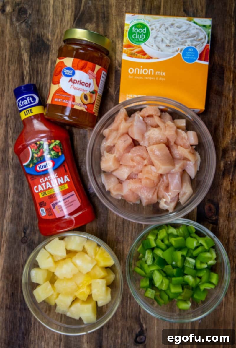 Sticky Sweet-Sour Chicken Bake 4 Individual ingredients laid out: boneless, skinless chicken breasts, Catalina salad dressing, apricot preserves, onion soup mix, pineapple chunks, and diced green peppers, ready for cooking.