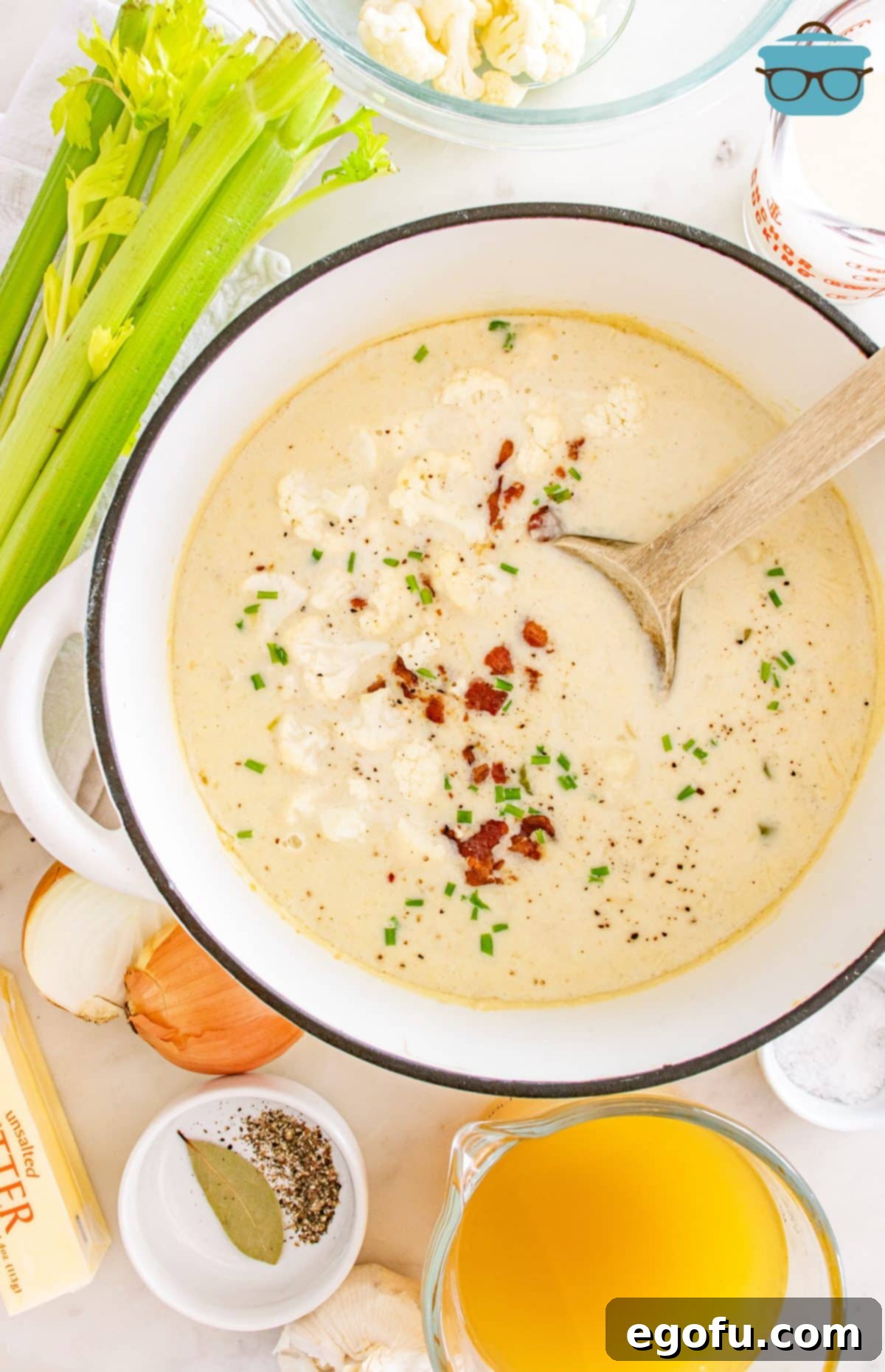 A ladle swirling a pot of creamy Loaded Cauliflower Soup, ready to be served.
