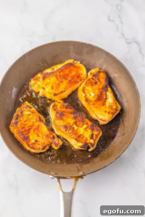 Pork chops in a skillet.