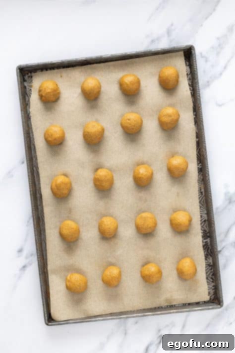 Pumpkin truffle dough being rolled into balls.