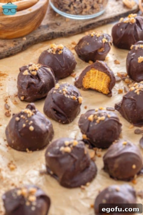 A sheet pan of Pumpkin Truffles with one bit in half.