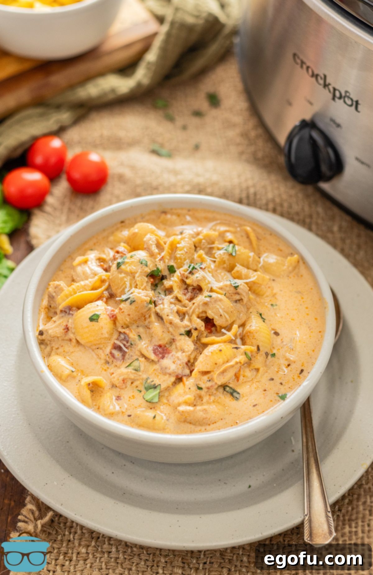 A bowl of Marry Me Chicken Soup on a charger with a spoon.