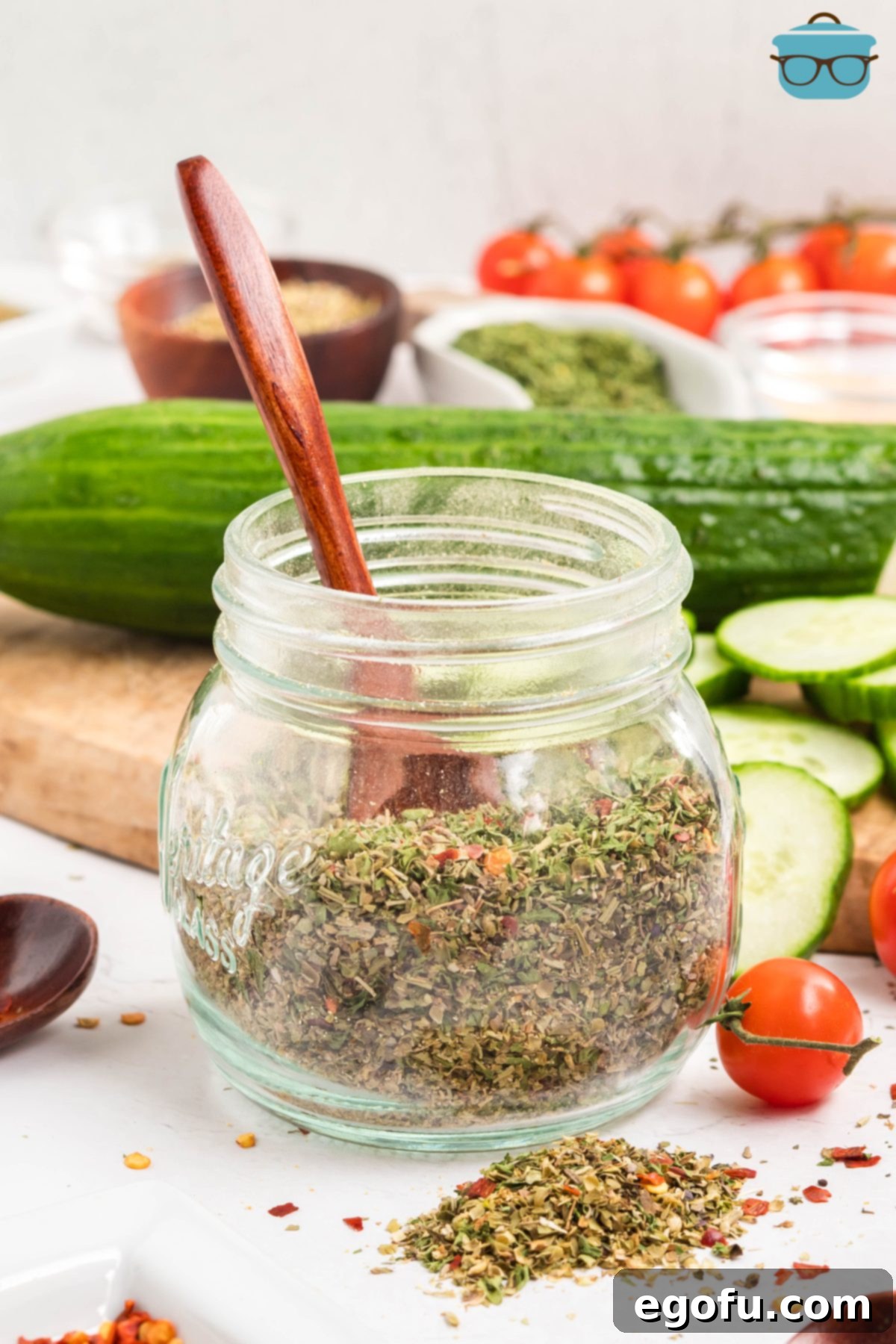 A wooden spoon in a jar of Homemade Italian Dressing Mix, showcasing its rich texture and vibrant colors.