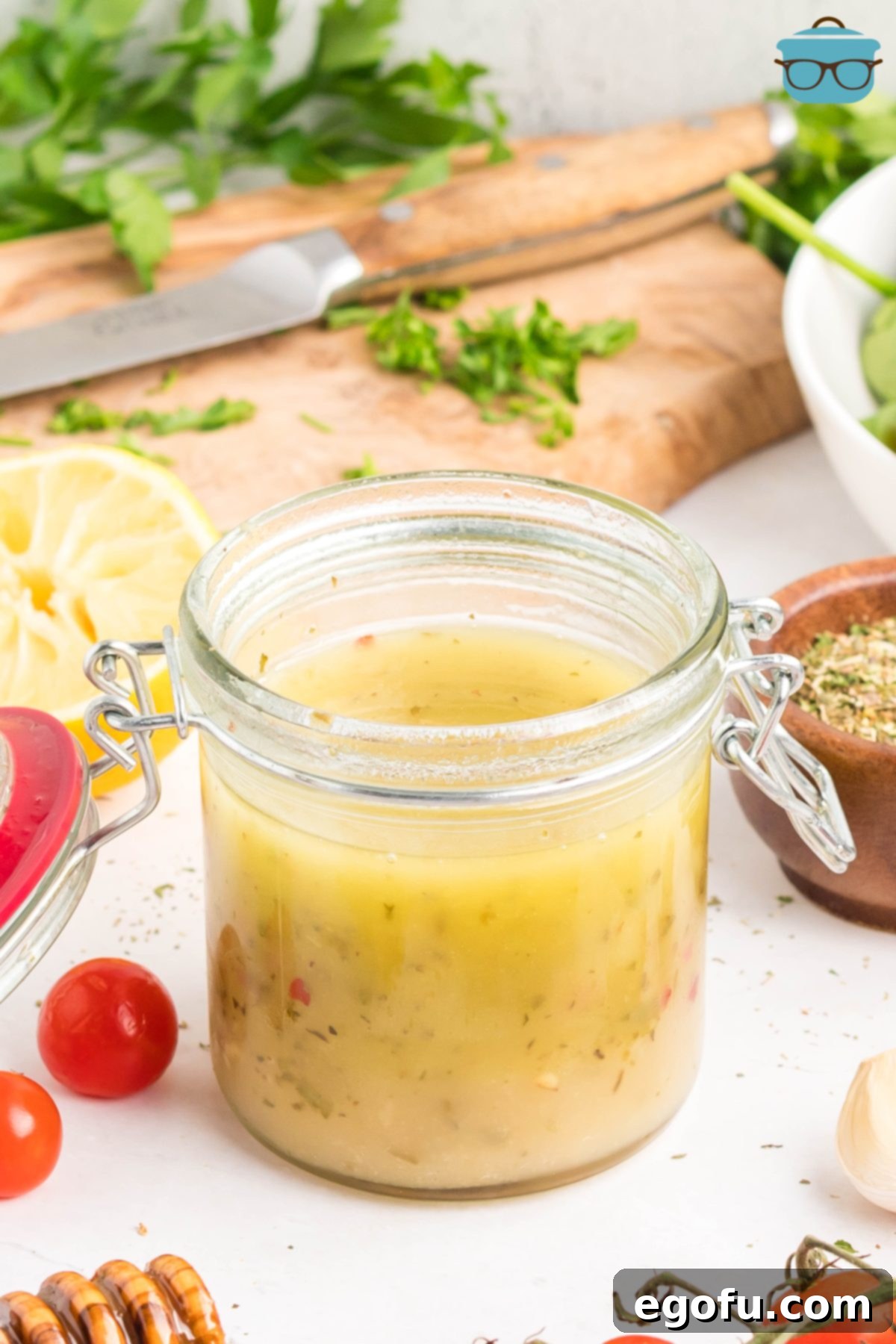 A jar of freshly made Homemade Italian Dressing, garnished with fresh herbs, ready to be served.
