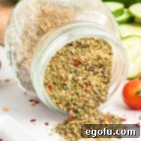 A jar of Italian Dressing Mix being dumped on a table, illustrating the rich texture of the homemade blend.