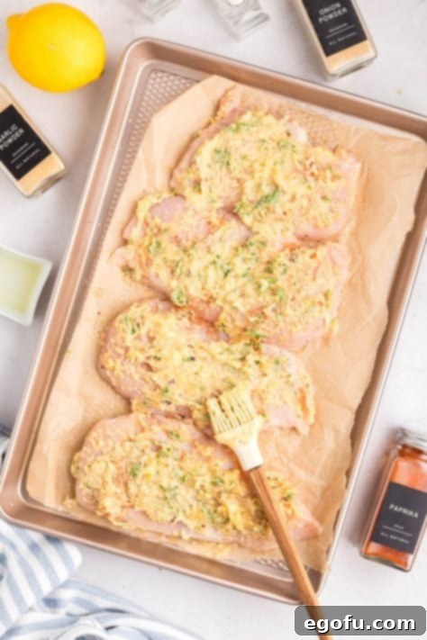 Garlic Parmesan Crusted Chicken 11 Sauce coated chicken breasts on a lined baking sheet.