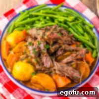 Looking down on a bowl of Crock Pot Catalina Roast Beef with potatoes and green beans.