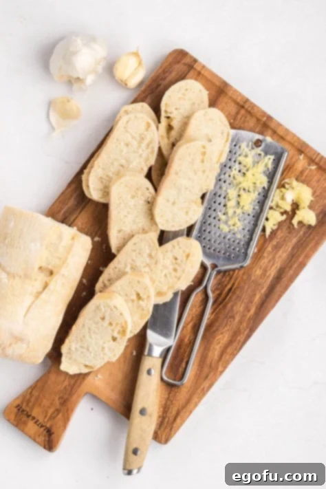 A baguette being sliced on a cutting board.